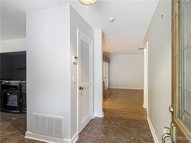 corridor featuring baseboards and visible vents