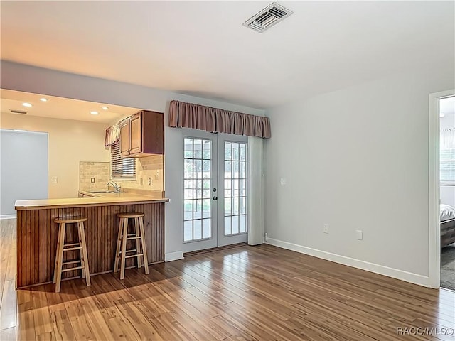kitchen with baseboards, hardwood / wood-style floors, and visible vents