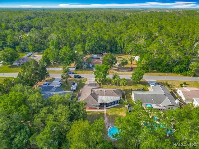 drone / aerial view featuring a residential view and a wooded view