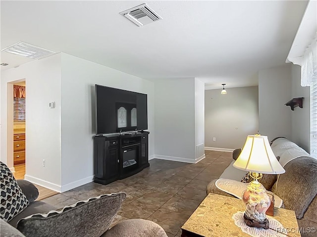 living area featuring baseboards and visible vents