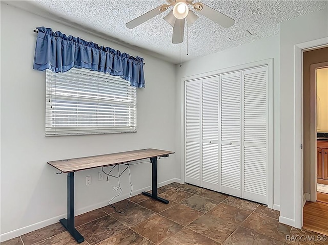 interior space featuring ceiling fan, a textured ceiling, visible vents, baseboards, and a closet
