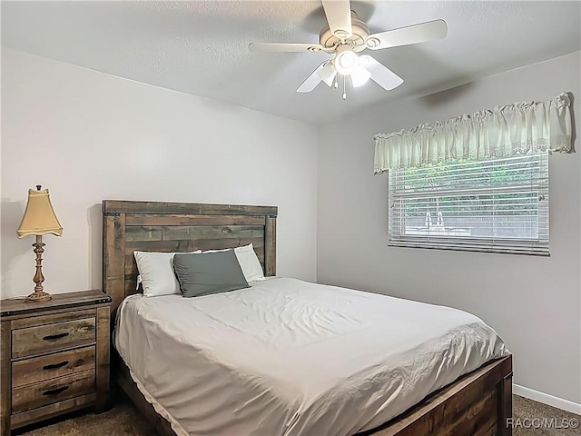 bedroom with baseboards, ceiling fan, and dark colored carpet