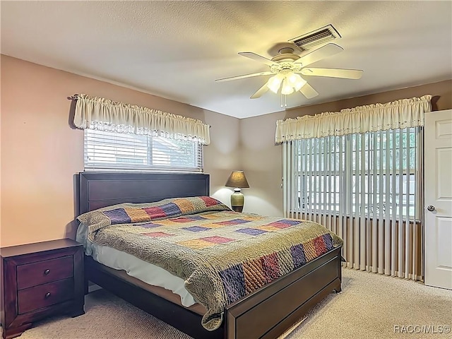bedroom featuring visible vents, ceiling fan, and light colored carpet