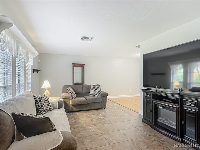 living area with baseboards and visible vents