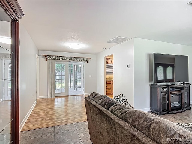 living area featuring baseboards and visible vents