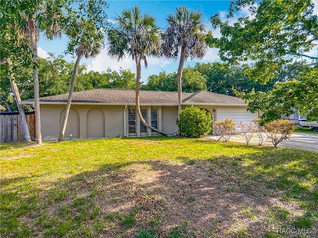 single story home with a front yard, fence, an attached garage, a shingled roof, and stucco siding