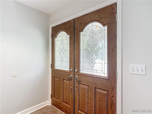 tiled entryway featuring baseboards, plenty of natural light, and french doors