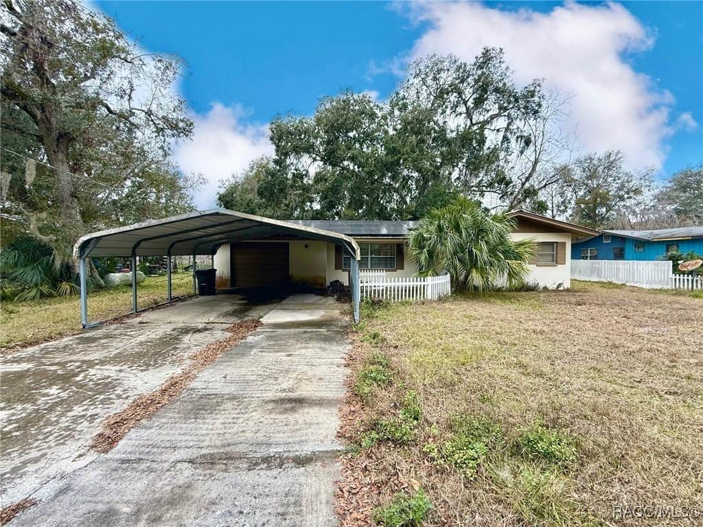 view of front of property with a front yard and a carport