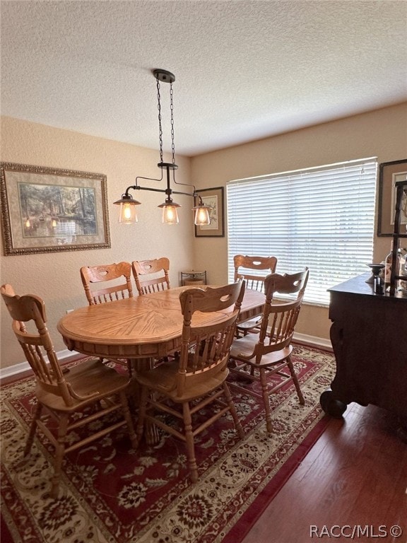 dining area featuring hardwood / wood-style floors and a textured ceiling