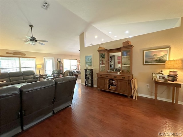 living room featuring lofted ceiling, dark wood-type flooring, and a wealth of natural light