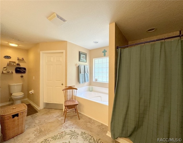 bathroom featuring toilet, a textured ceiling, and independent shower and bath