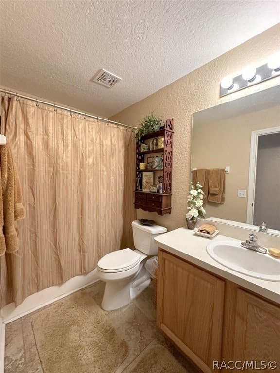 bathroom featuring vanity, toilet, and a textured ceiling