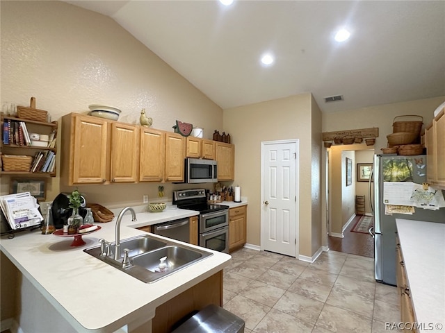 kitchen with kitchen peninsula, stainless steel appliances, vaulted ceiling, sink, and light tile patterned floors