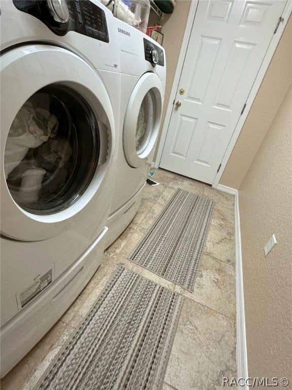 clothes washing area with washing machine and dryer