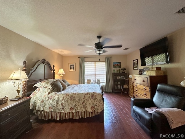 bedroom featuring a textured ceiling, ceiling fan, and dark wood-type flooring