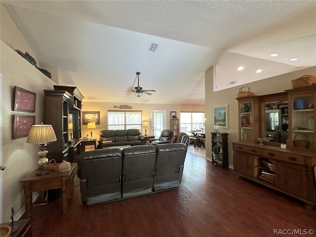 living room featuring a textured ceiling, ceiling fan, dark hardwood / wood-style floors, and vaulted ceiling