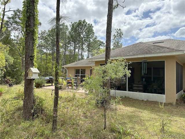 view of yard with a sunroom and a patio