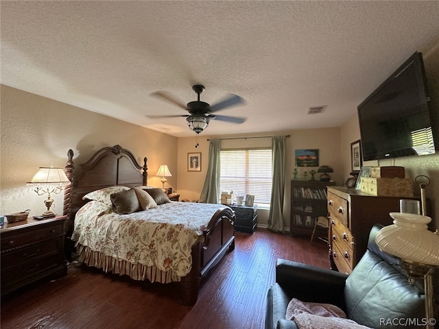 bedroom featuring ceiling fan, dark hardwood / wood-style floors, and a textured ceiling