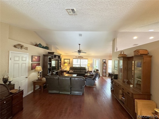 living room featuring vaulted ceiling, ceiling fan, a textured ceiling, and dark hardwood / wood-style floors