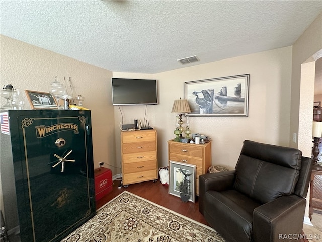 sitting room with a textured ceiling and dark wood-type flooring