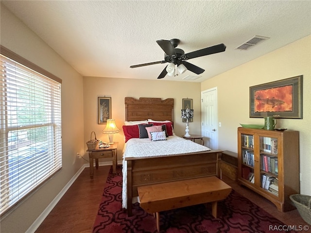 bedroom featuring a textured ceiling, ceiling fan, and dark hardwood / wood-style floors