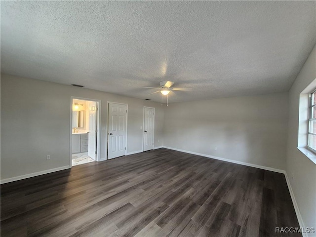 unfurnished bedroom with a textured ceiling, ceiling fan, ensuite bathroom, and dark hardwood / wood-style floors