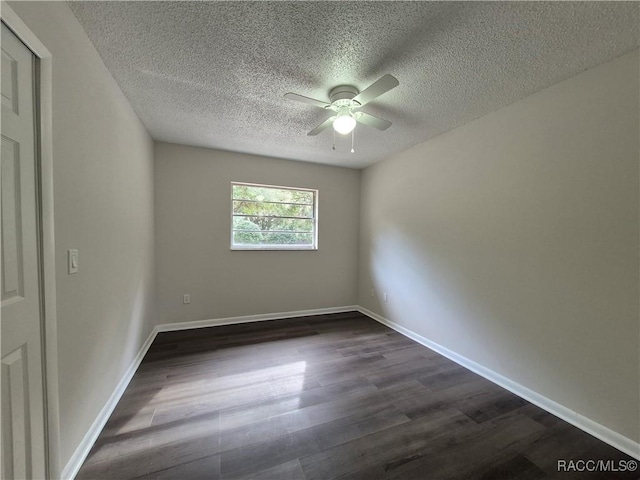 spare room with ceiling fan, dark hardwood / wood-style floors, and a textured ceiling