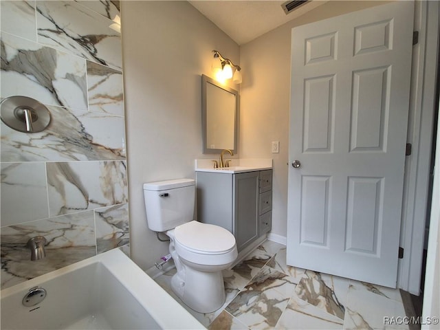 bathroom with vaulted ceiling, toilet, a bathtub, and vanity