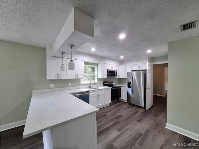 kitchen featuring pendant lighting, white cabinets, appliances with stainless steel finishes, sink, and kitchen peninsula