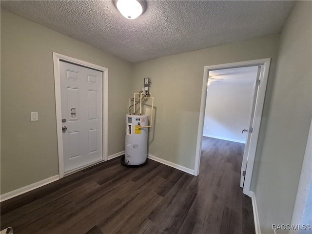 entryway with water heater, dark wood-type flooring, and a textured ceiling