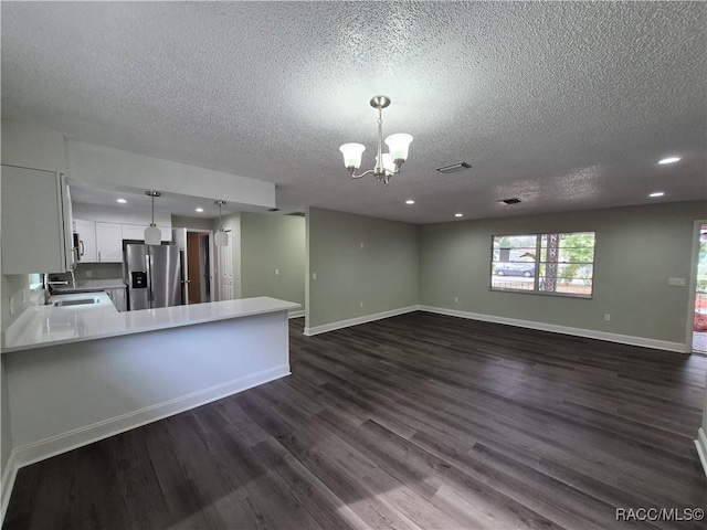 kitchen featuring decorative light fixtures, sink, stainless steel fridge with ice dispenser, white cabinets, and a chandelier