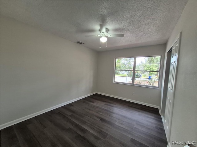 empty room featuring a textured ceiling, ceiling fan, and dark hardwood / wood-style flooring