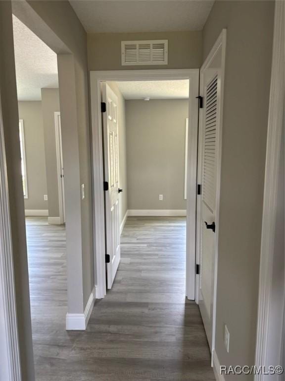 corridor featuring wood finished floors and baseboards