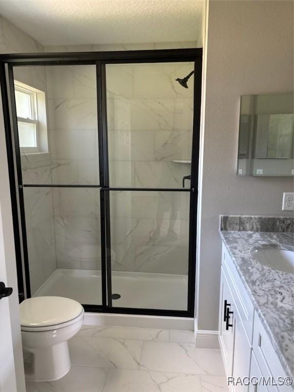 bathroom with a shower stall, vanity, marble finish floors, and toilet
