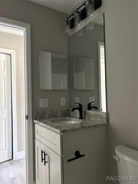half bathroom featuring vanity and toilet