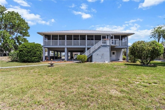 2168 N Watersedge Dr, Crystal River, FL 34429 - rear view of house with a sunroom, a lawn, stairs, and a metal roof