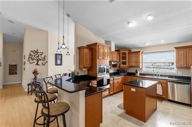 2168 N Watersedge Dr, Crystal River, FL 34429 - kitchen with appliances with stainless steel finishes, a peninsula, a kitchen bar, brown cabinetry, and glass insert cabinets