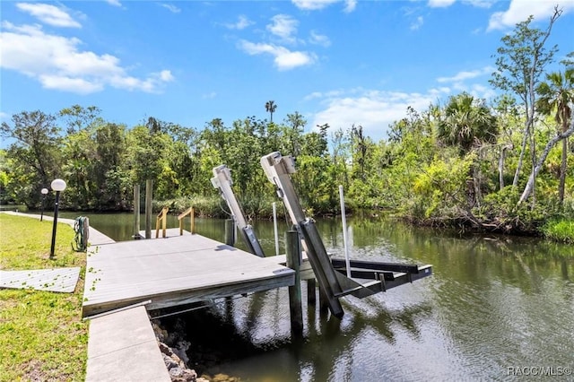 2168 N Watersedge Dr, Crystal River, FL 34429 - dock area featuring boat lift, a water view, and view of wooded area