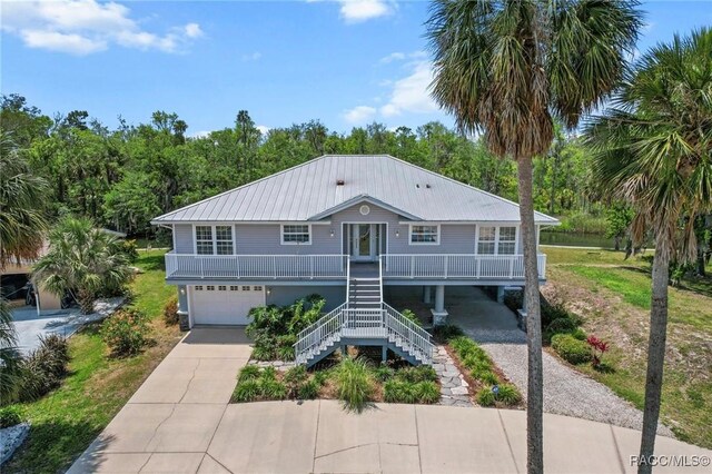 2168 N Watersedge Dr, Crystal River, FL 34429 - beach home featuring concrete driveway, stairs, a metal roof, an attached garage, and covered porch