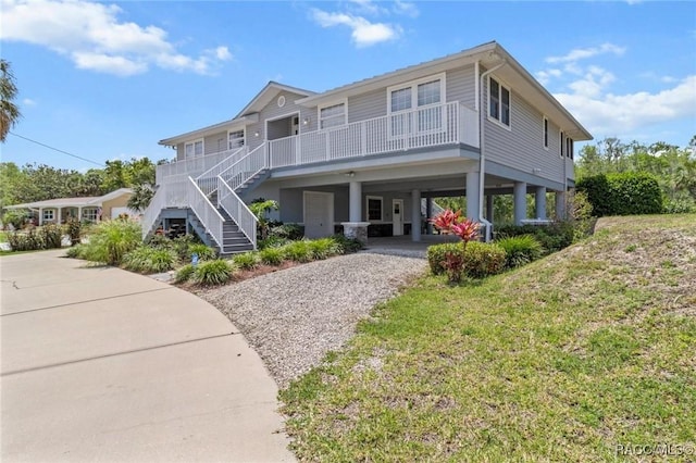 2168 N Watersedge Dr, Crystal River, FL 34429 - coastal inspired home with gravel driveway, a carport, stairs, and covered porch