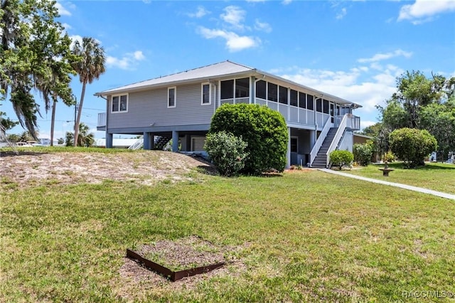 2168 N Watersedge Dr, Crystal River, FL 34429 - back of house with stairs, a sunroom, a carport, and a lawn