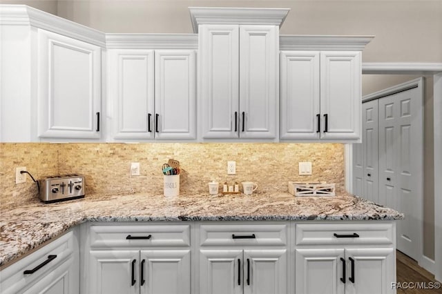 5888 W Corral Pl, Beverly Hills, FL 34465 - kitchen with white cabinets, decorative backsplash, light stone countertops, and wood finished floors