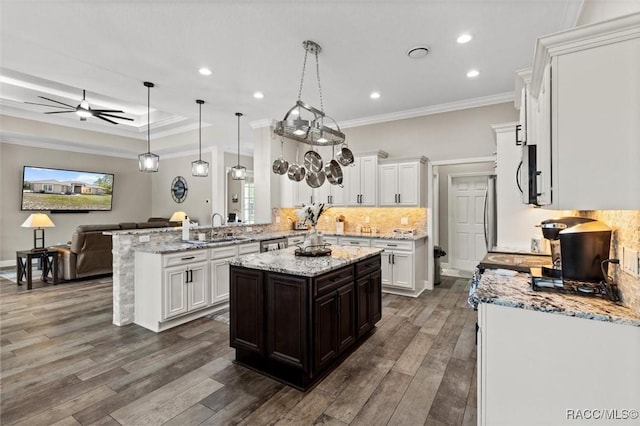 5888 W Corral Pl, Beverly Hills, FL 34465 - kitchen featuring a peninsula, decorative backsplash, ceiling fan, ornamental molding, and white cabinets