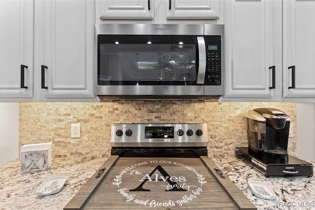 5888 W Corral Pl, Beverly Hills, FL 34465 - kitchen with stainless steel appliances, decorative backsplash, white cabinets, and light stone counters