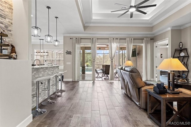 5888 W Corral Pl, Beverly Hills, FL 34465 - living room featuring a tray ceiling, a ceiling fan, dark wood-style floors, crown molding, and baseboards
