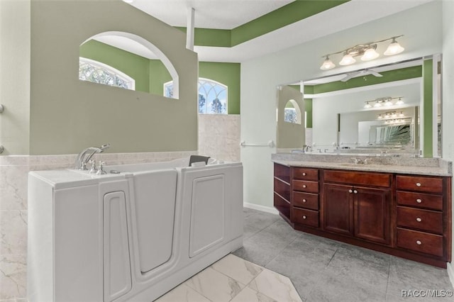 4491 W Stable Ct, Beverly Hills, FL 34465 - bathroom featuring a garden tub, vanity, and healthy amount of natural light