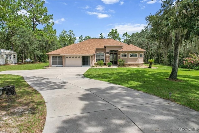 4491 W Stable Ct, Beverly Hills, FL 34465 - mediterranean / spanish home featuring stucco siding, a garage, driveway, and a front lawn