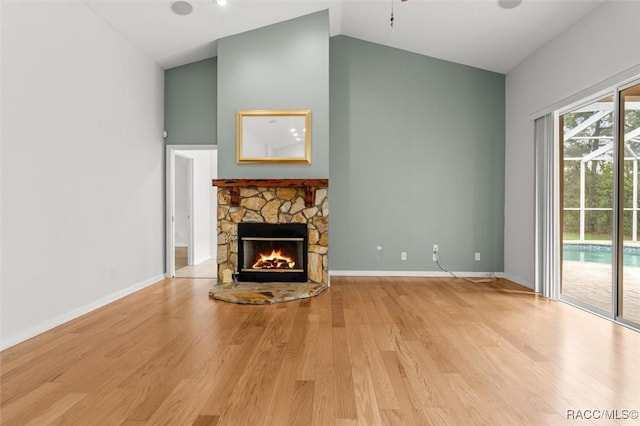 4491 W Stable Ct, Beverly Hills, FL 34465 - unfurnished living room featuring a stone fireplace, high vaulted ceiling, and light wood-style flooring