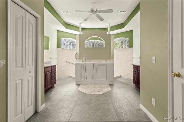 4491 W Stable Ct, Beverly Hills, FL 34465 - full bath featuring two vanities, a ceiling fan, a garden tub, and a closet