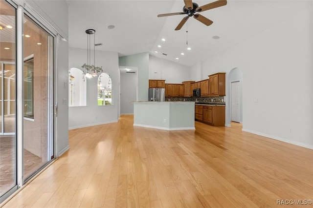 4491 W Stable Ct, Beverly Hills, FL 34465 - kitchen with open floor plan, appliances with stainless steel finishes, arched walkways, ceiling fan, and brown cabinetry